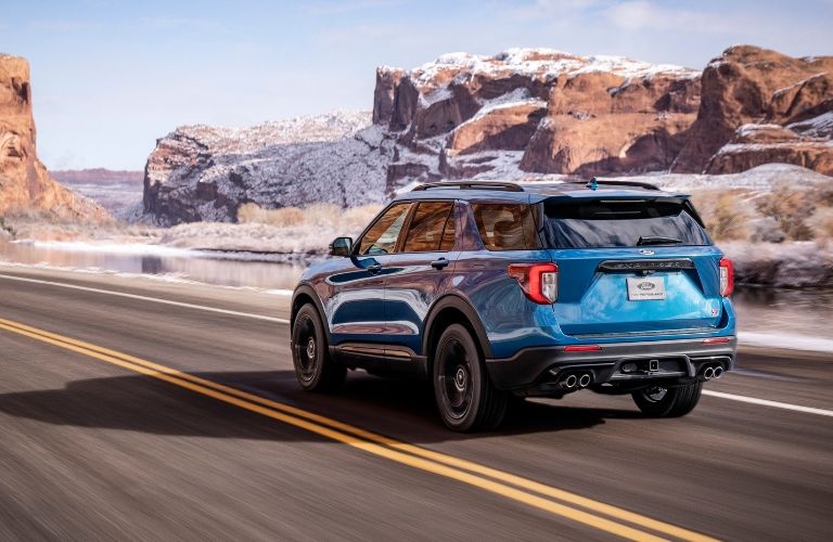 Blue_2020_Ford_Explorer_driving_by_a_snowy_desert_landscape_o