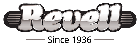 Red Ford F-150 Lightning electric pickup truck parked on a desert road with a rocky landscape in the background.