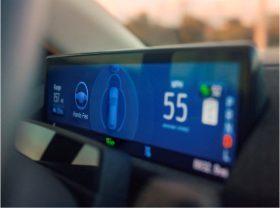 Close-up of a car dashboard display showing a hands-free driving mode active, with a speed of 55 mph and additional driving information.