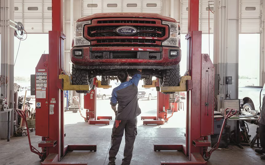 Mechanic inspecting the underside of a vehicle