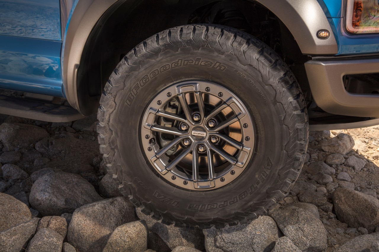 Roue avant d'un Ford F-150 Raptor sur de la grosse roche