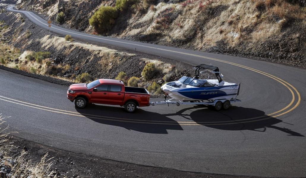 Ford Expedition blanche tirant une caravane sur route montagneuse