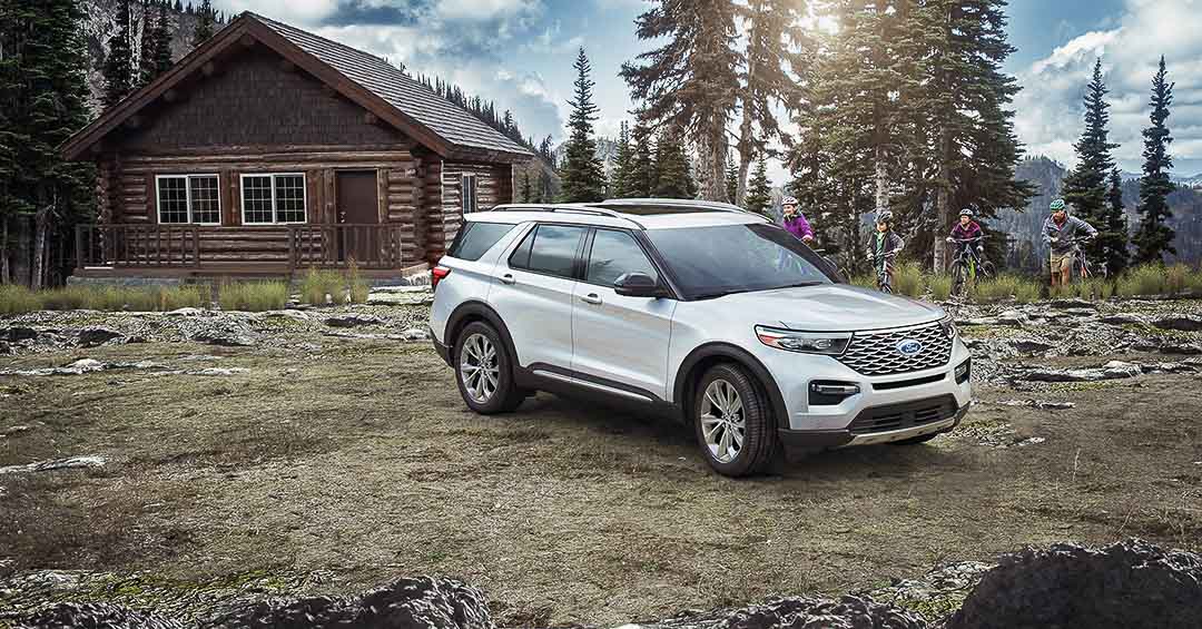 vue trois quart avant du Ford Explorer 2021 stationné proche d'un chalet