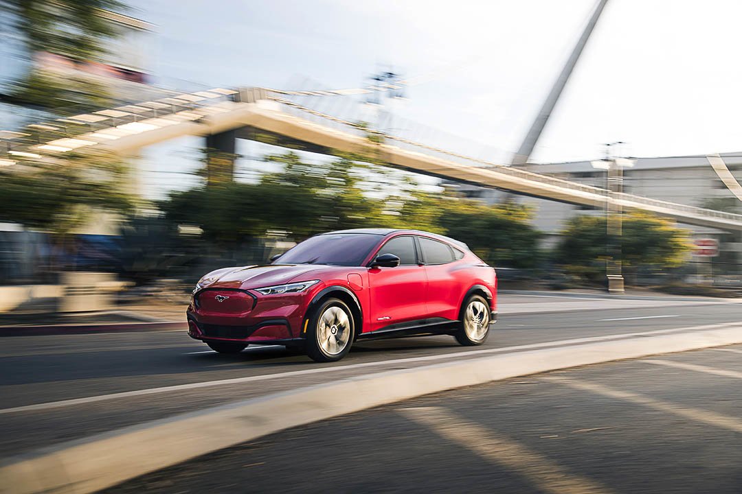 vue latérale avant du Ford Mustang Mach-E 2021 roulant sur une route en ville