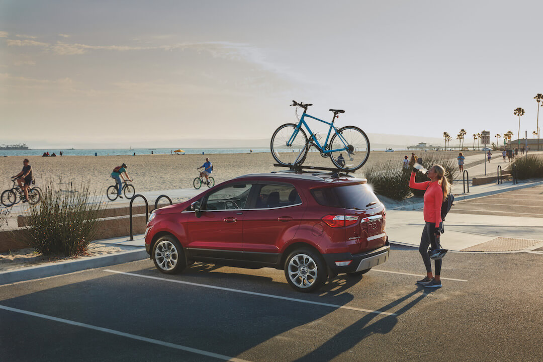 vue trois quart arrière du Ford EcoSport 2021 stationné proche de la plage avec un vélo sur son toit