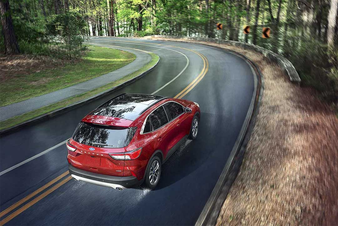 vue trois quart arrière du Ford Escape hybride rechargeable 2021 roulant sur une route
