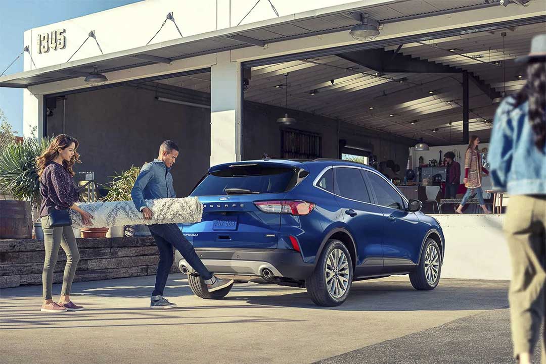 vue trois quart arrière du Ford Escape hybride rechargeable 2021 stationné devant un bâtiment