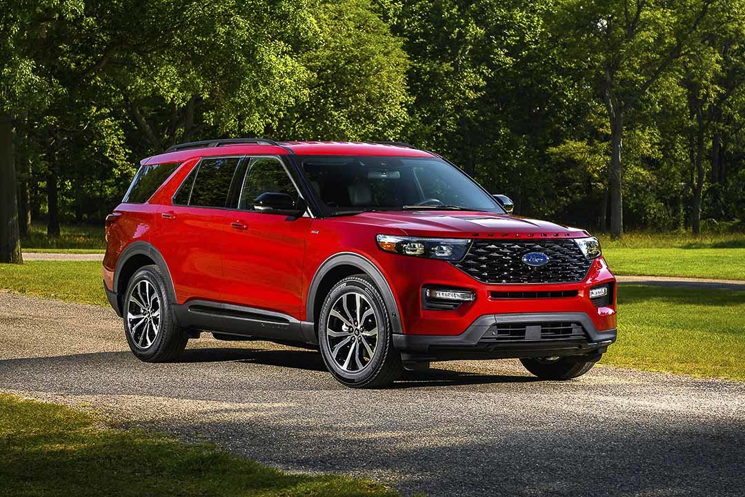 Vue 3/4 avant du VUS Ford Explorer ST Line 2022 rouge garé dans un parc urbain