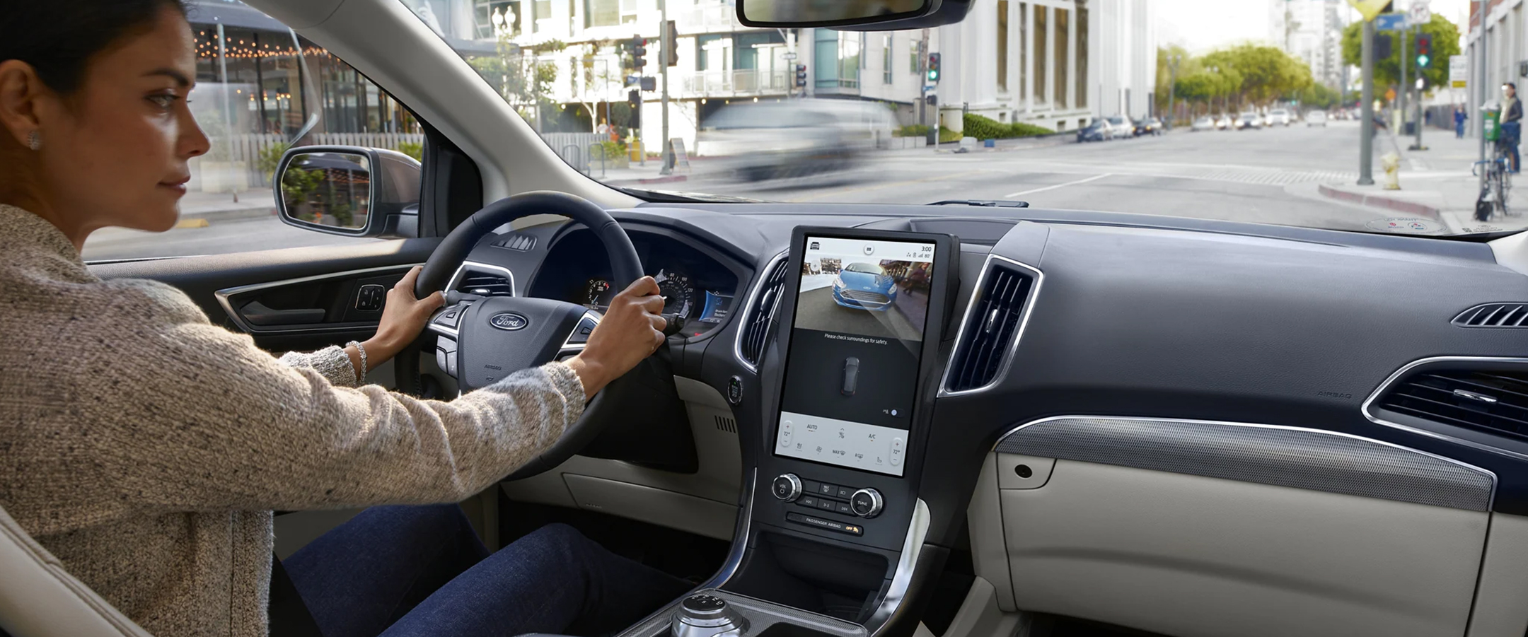 Woman parallel parking downtown in the 2023 Ford Edge utilizing the backup camera.