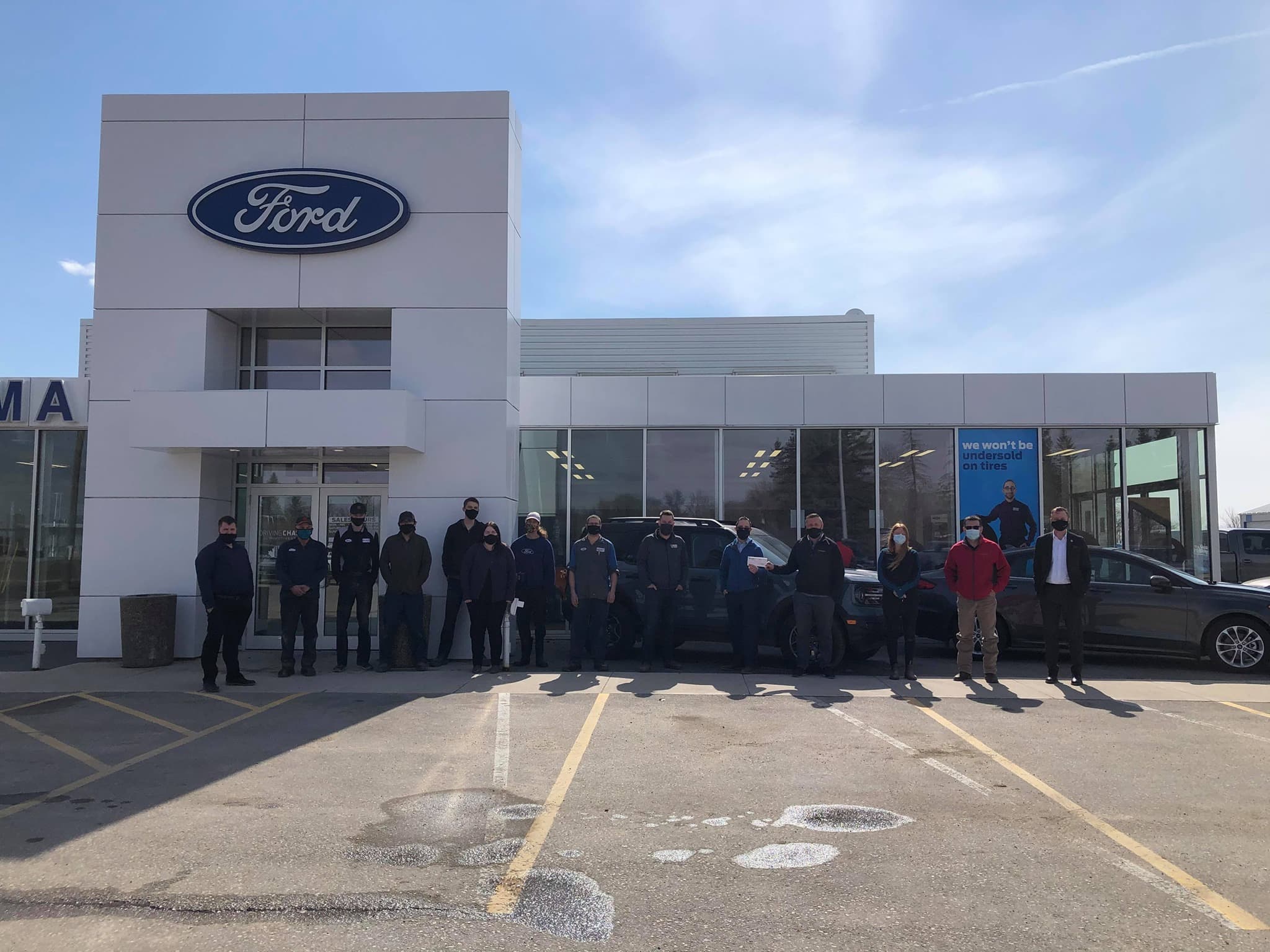 people in front of ford dealership