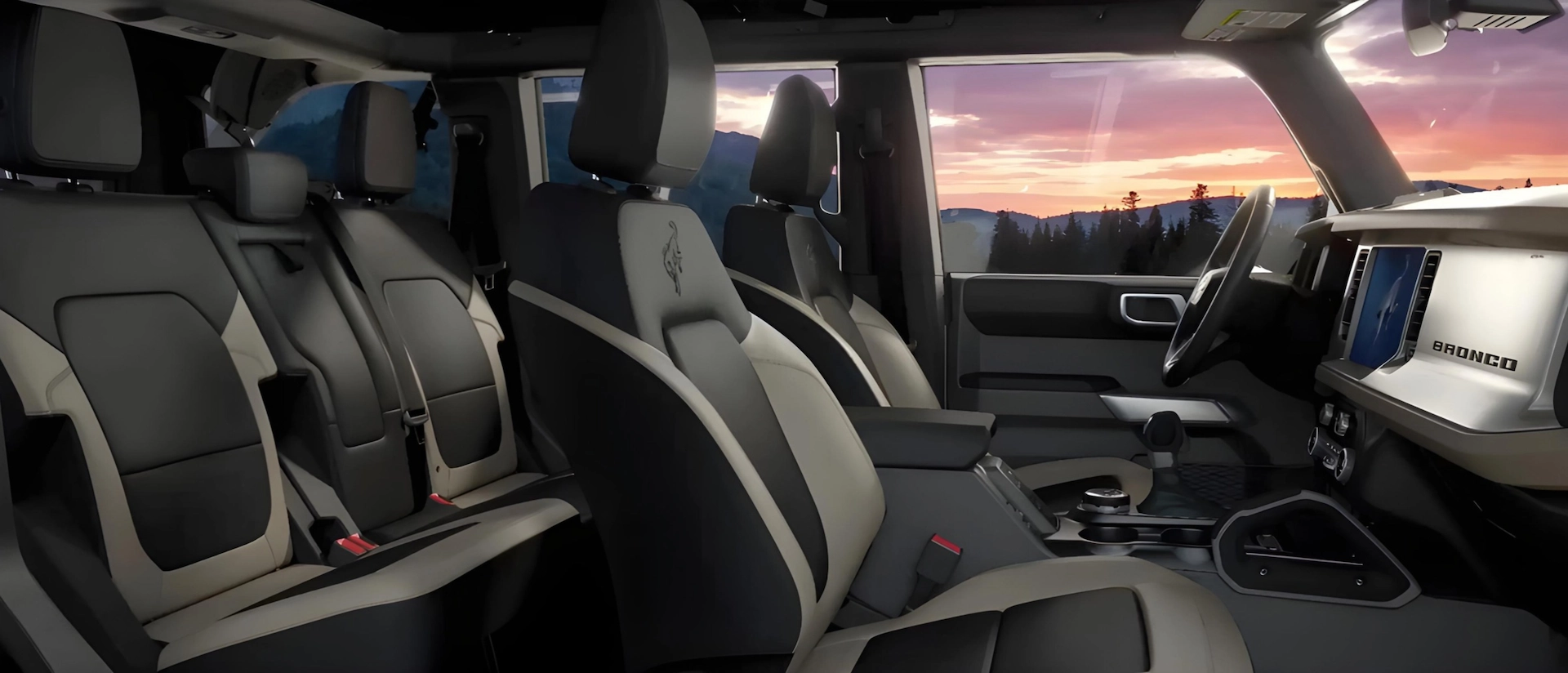 Habitacle du Ford Bronco 2026 avec sièges bicolores, banquette arrière et console centrale.