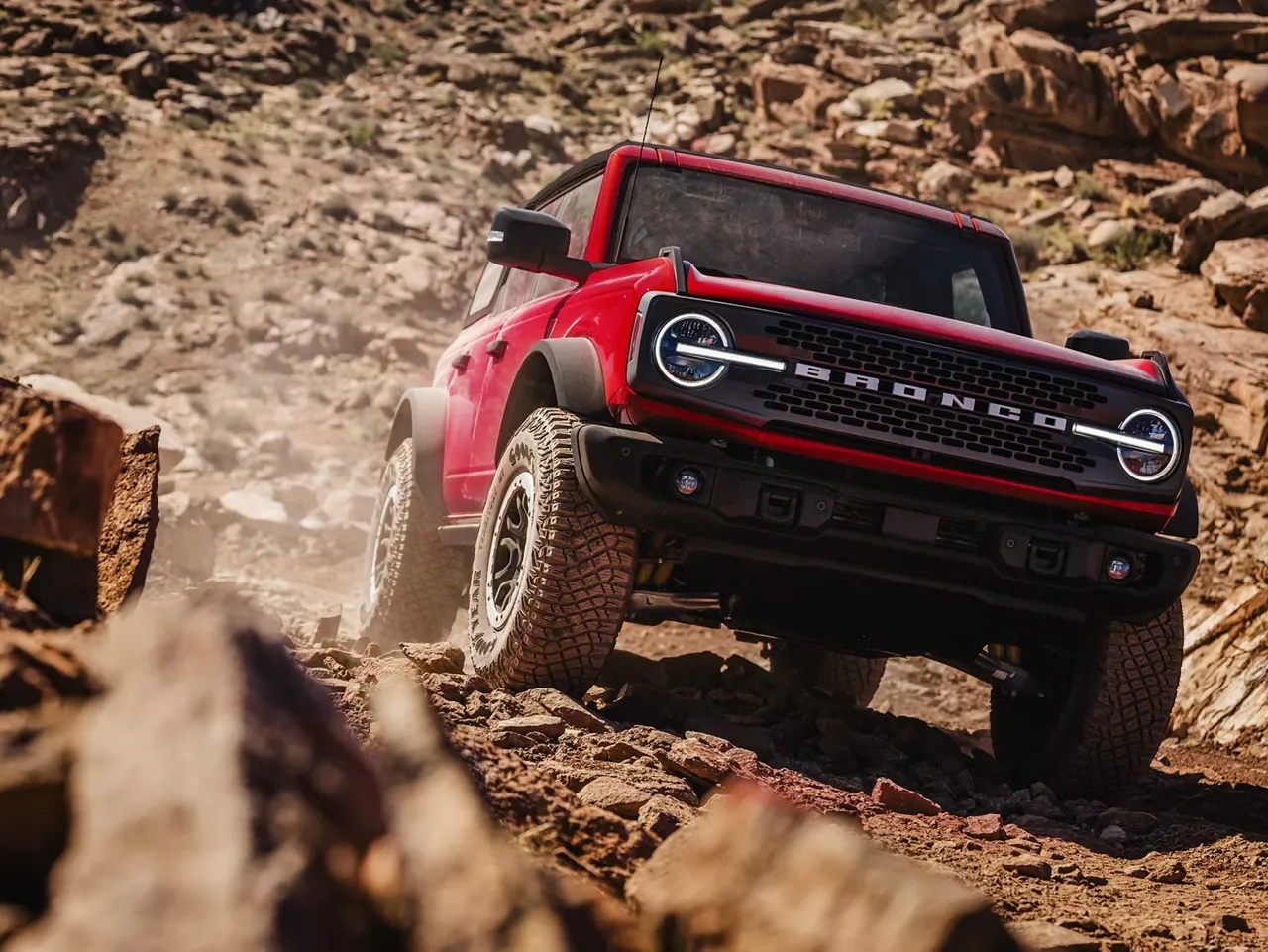 Ford Bronco 2026 rouge mettant en valeur son design extérieur sur un sentier rocheux.
