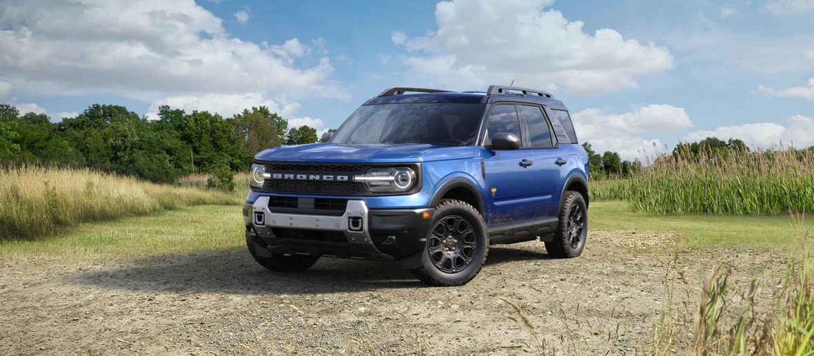 Ford Bronco Sport 2026 bleu stationné sur un terrain de campagne.