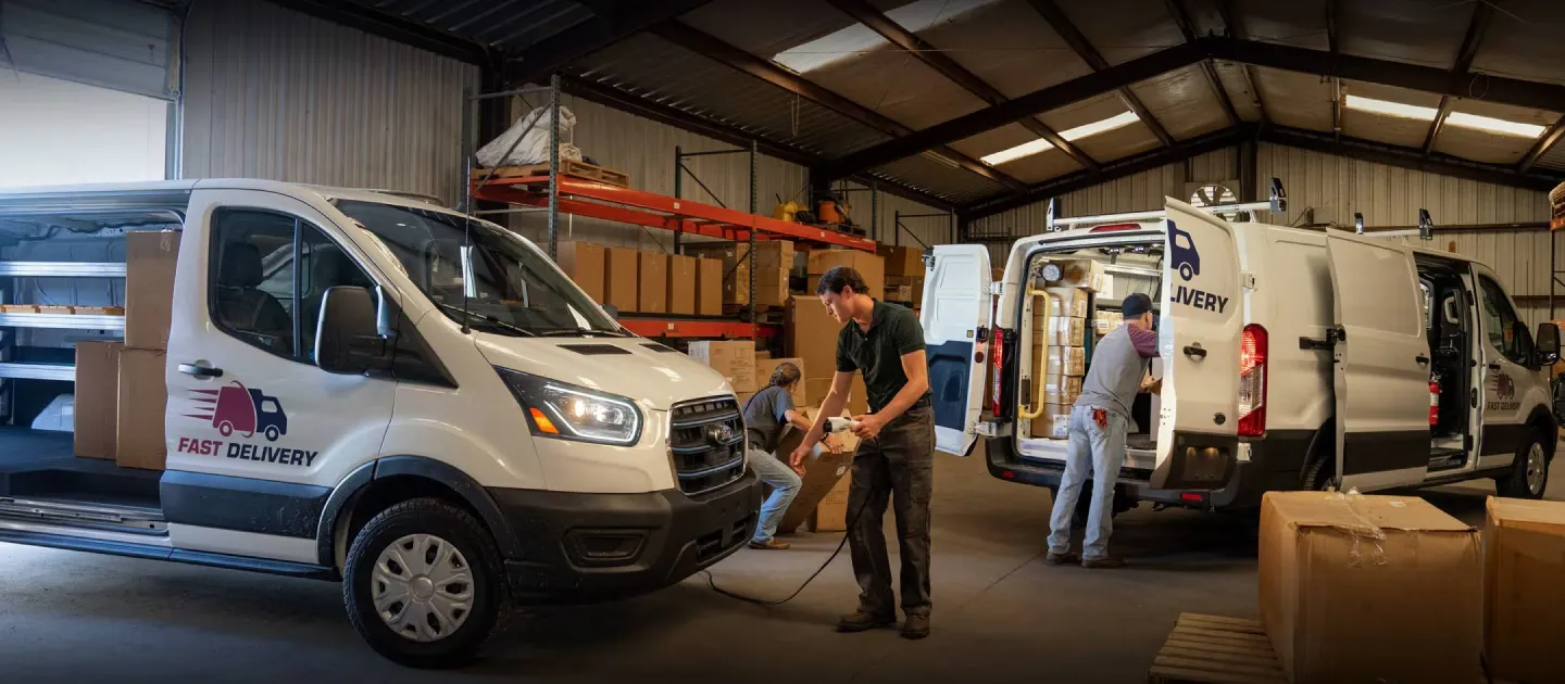 Fourgonnettes Ford E-Transit utilisées pour des livraisons dans un entrepôt.