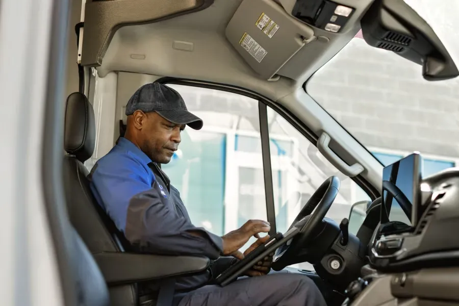 Conducteur utilisant les technologies numériques à bord du Ford E-Transit.