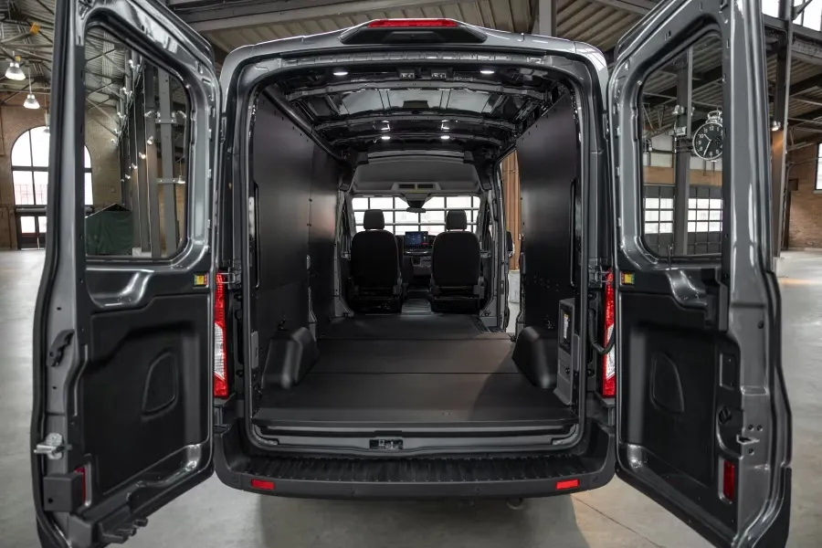 Espace de chargement spacieux du Ford E-Transit avec portes arrière ouvertes.