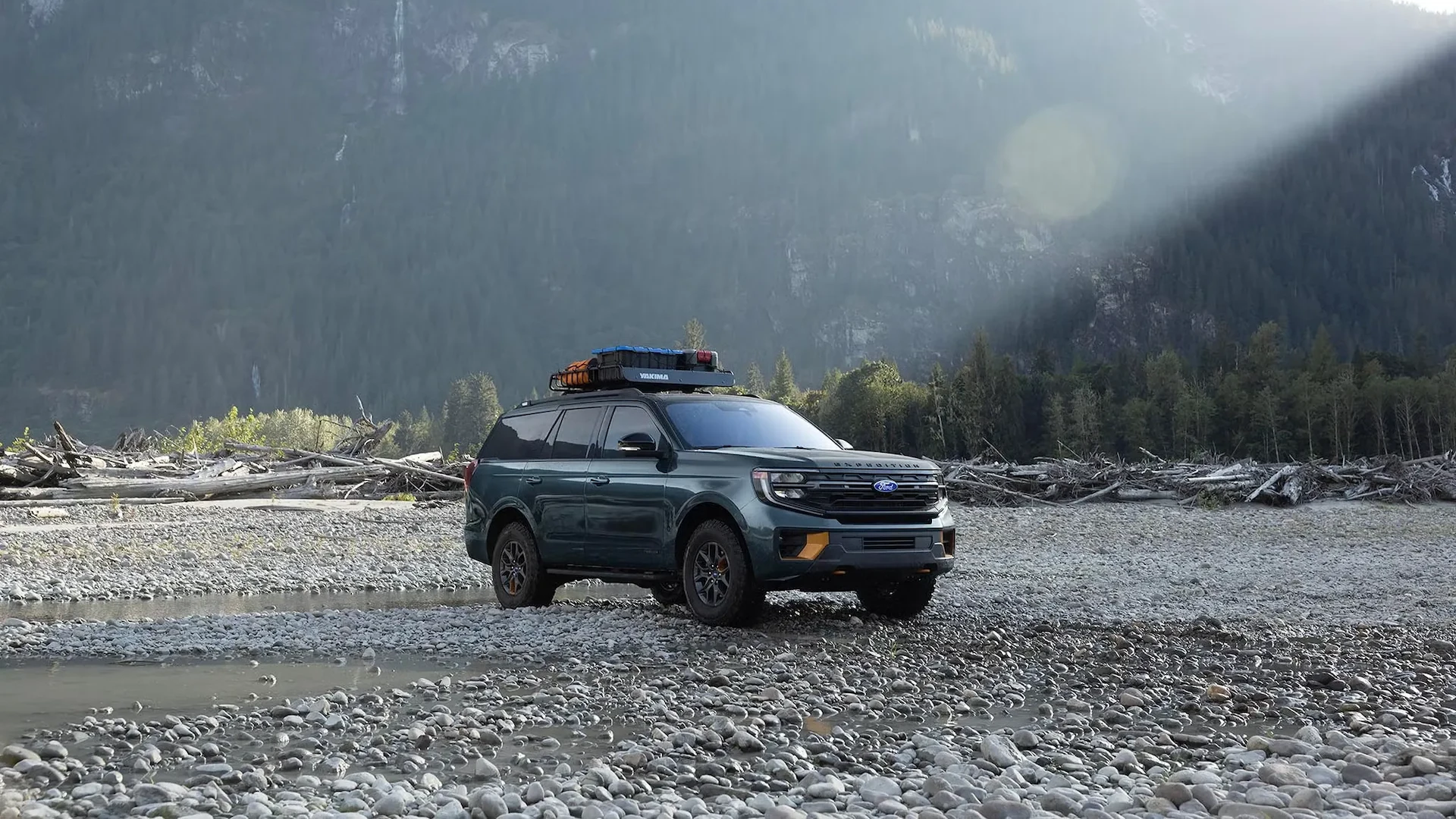Ford Expedition 2027 avec équipement sur le toit, stationné sur un terrain rocheux au pied des montagnes.