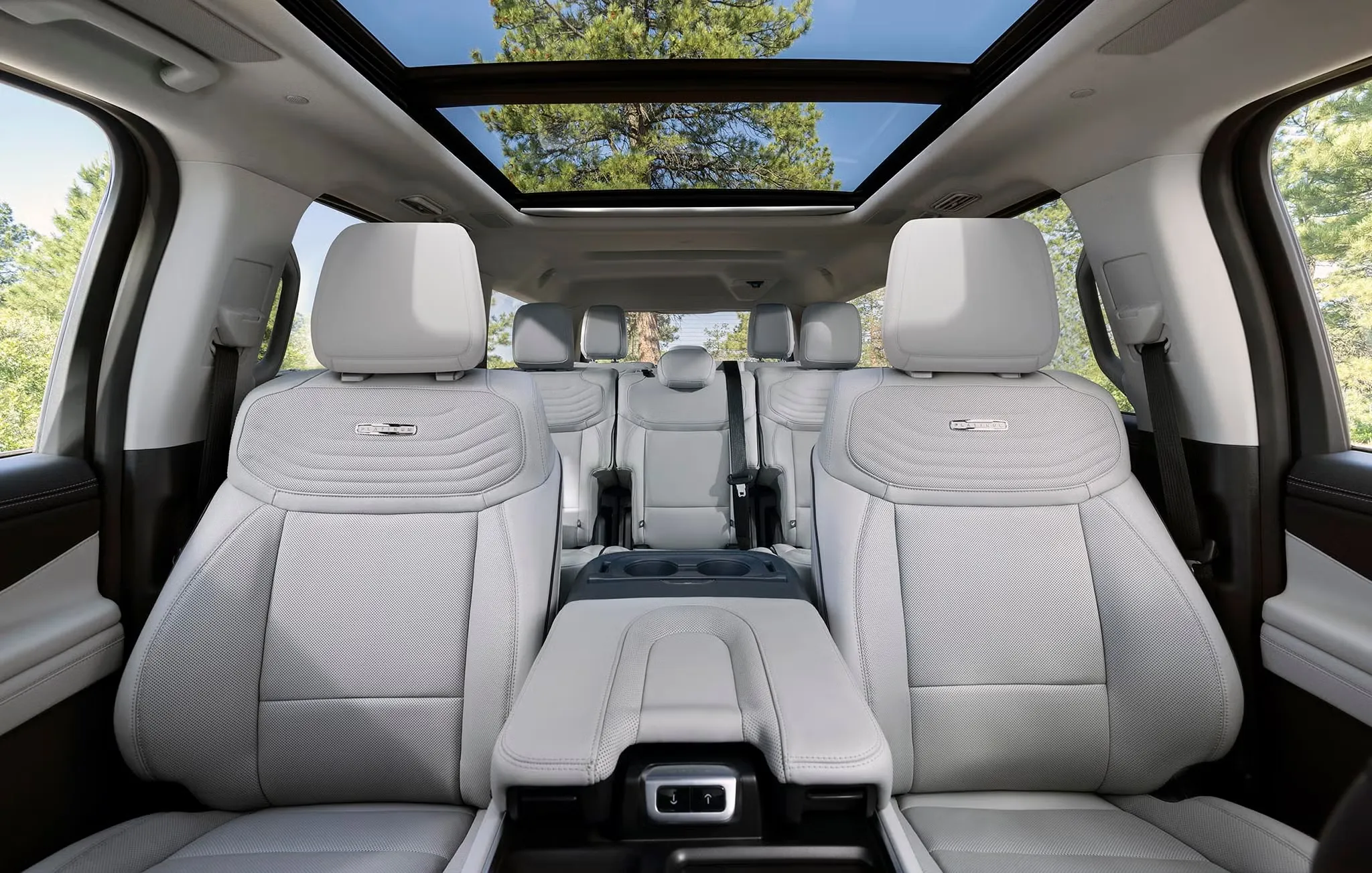 Habitacle du Ford Expedition 2027 avec trois rangées de sièges clairs et toit panoramique.