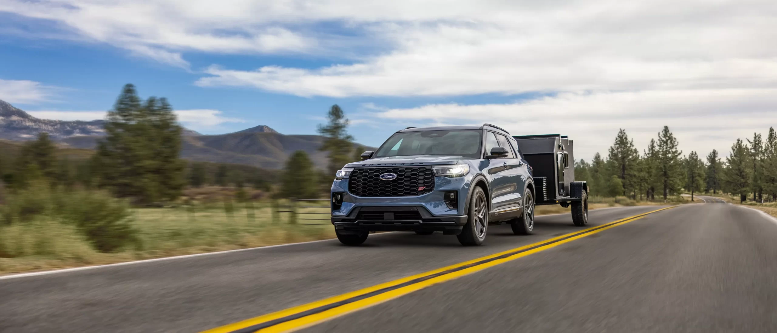 Ford Explorer remorquant une roulotte sur une route de montagne.