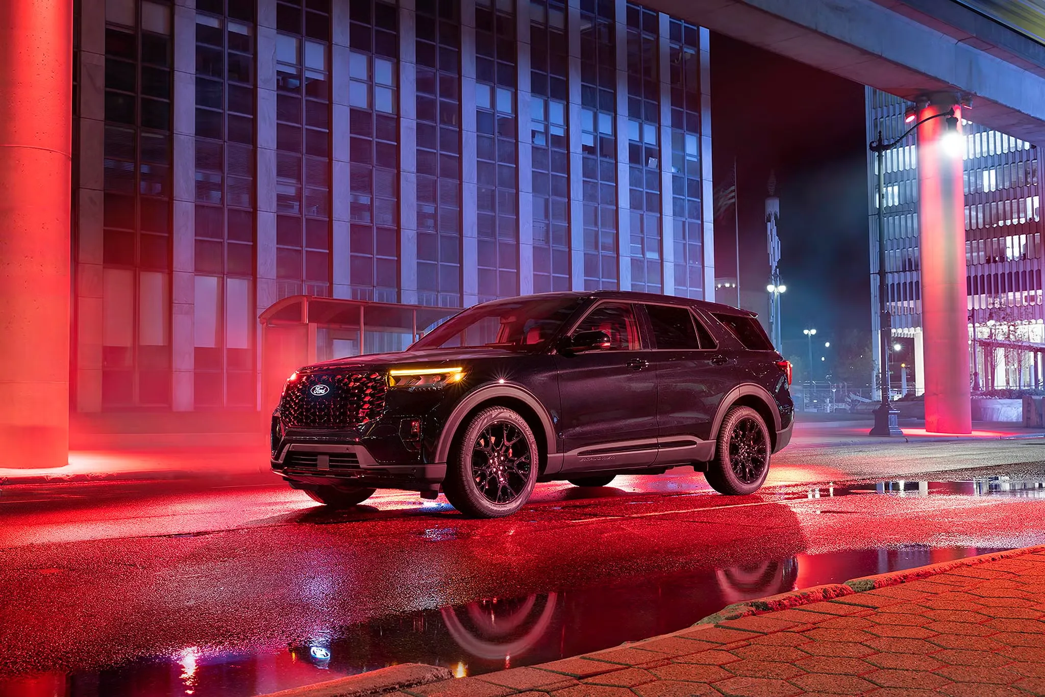 Ford Explorer 2027 stationné en ville la nuit sous des éclairages rouges et bleus.