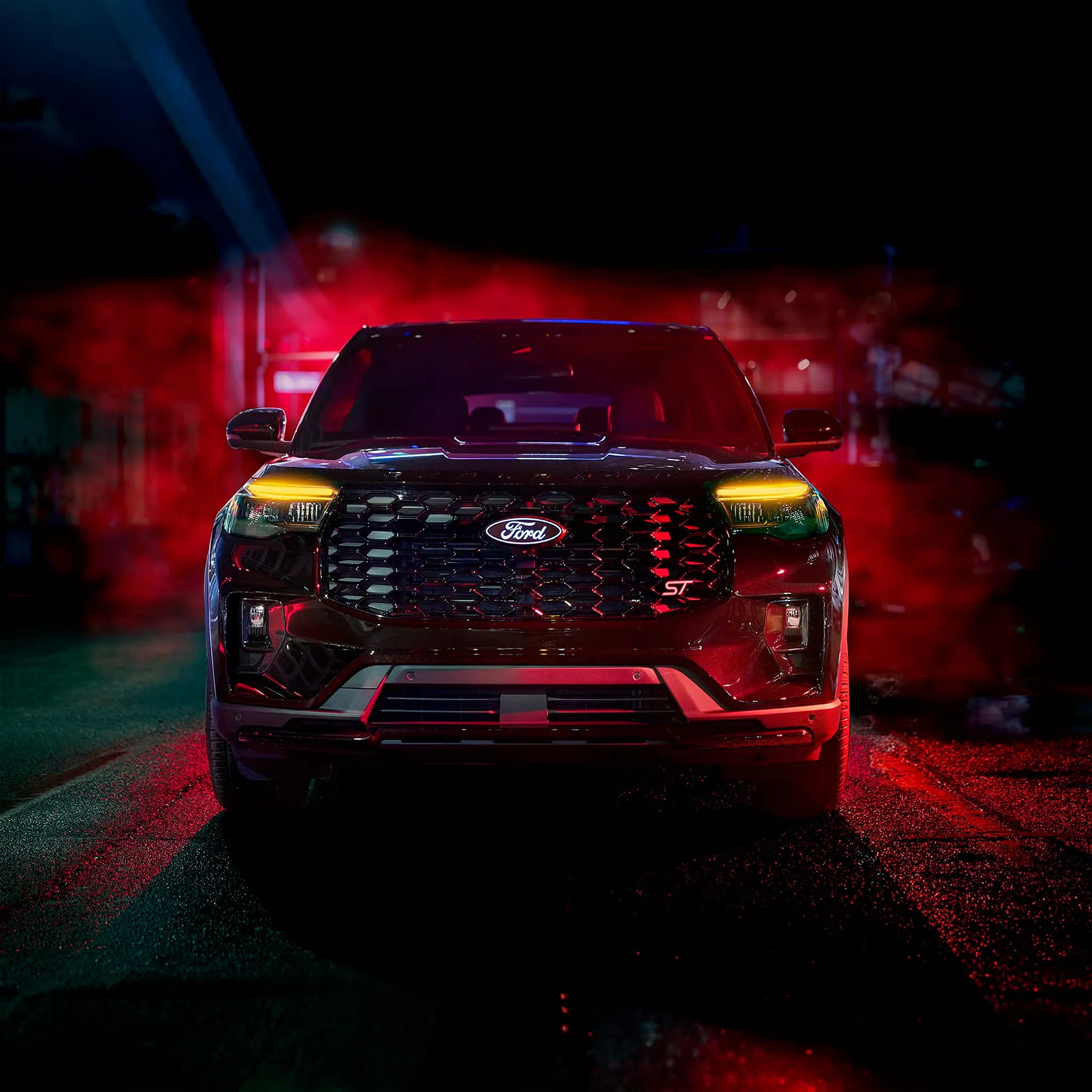 Vue de face du Ford Explorer 2027 avec sa large calandre et ses feux allumés dans un décor urbain nocturne.