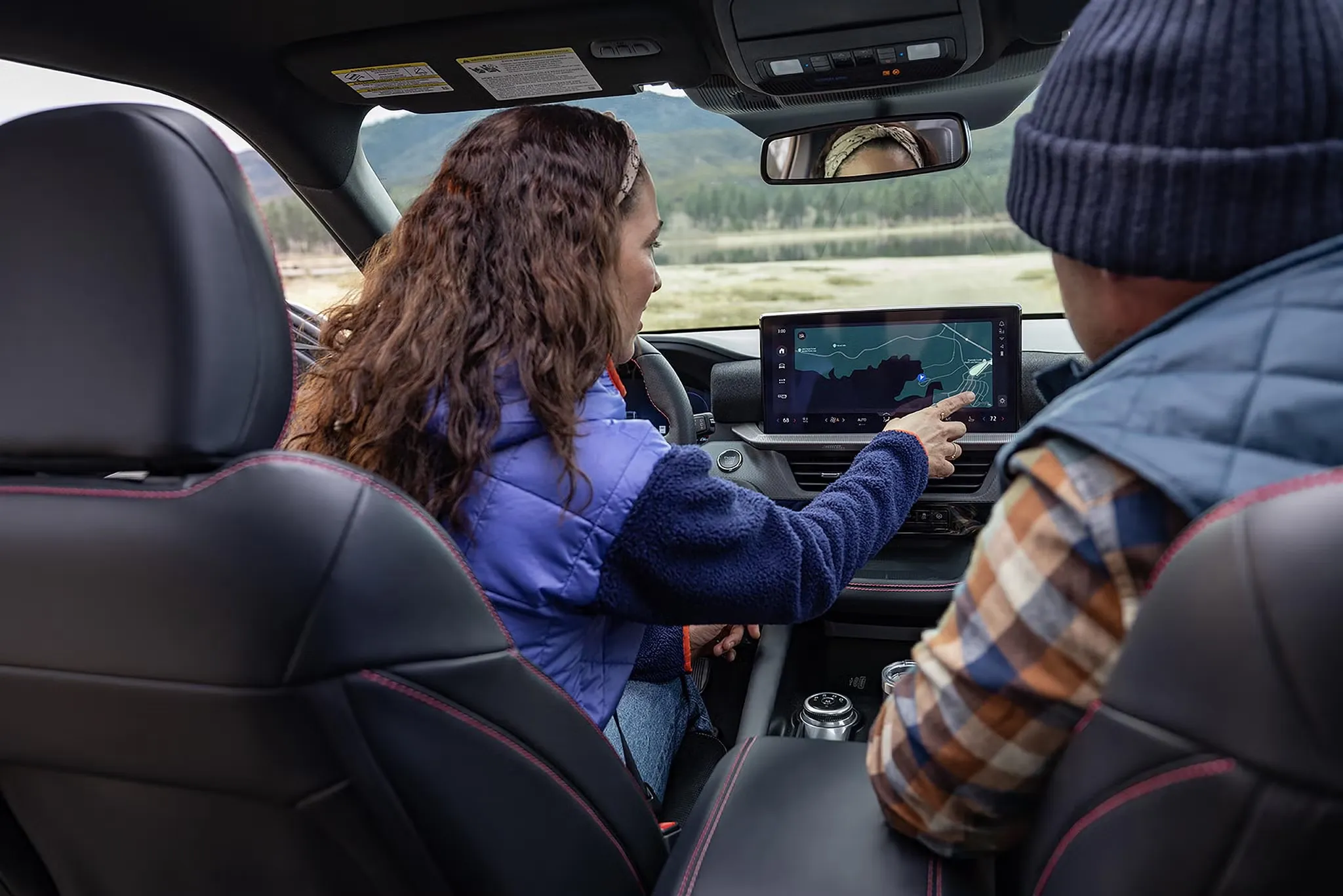Conductrice utilisant l’écran central du système d’infodivertissement du Ford Explorer 2027.