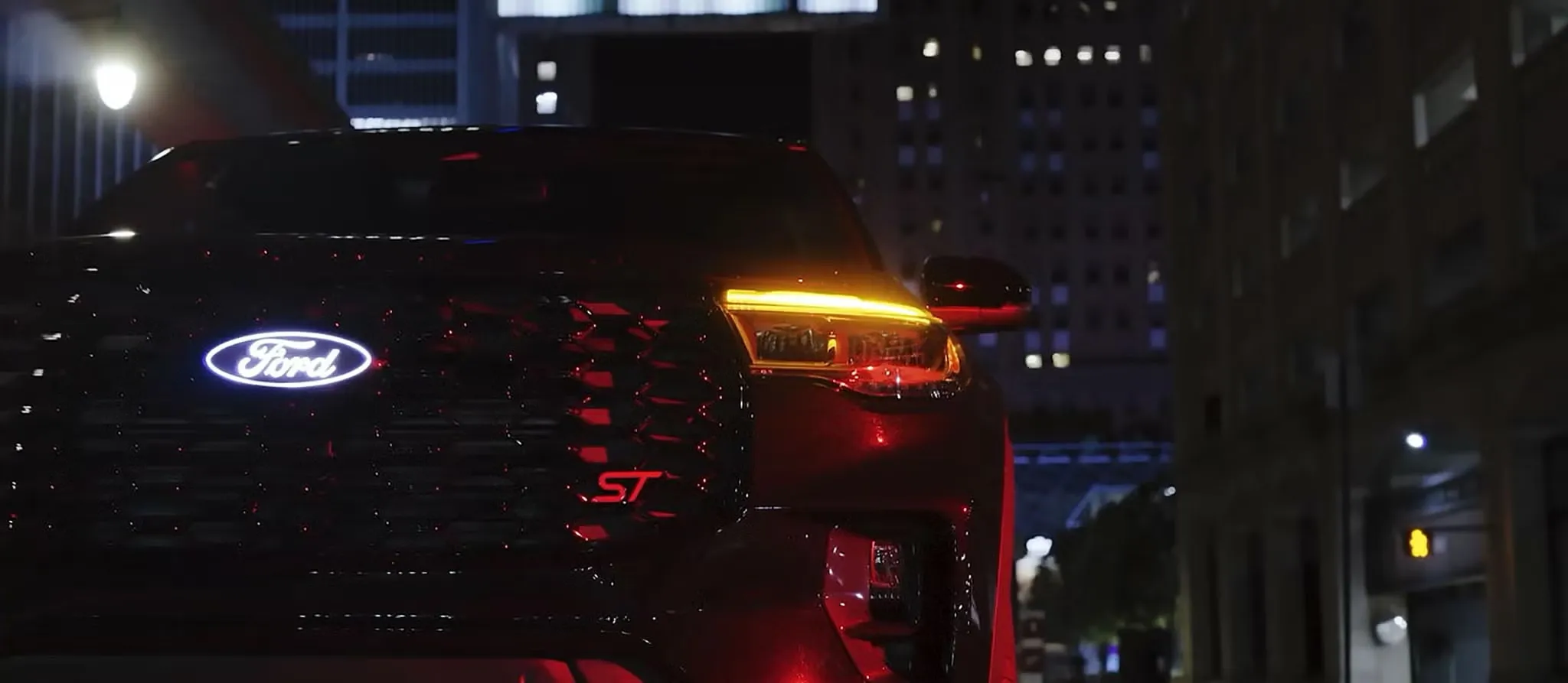 Gros plan sur la calandre, l’emblème ST et le feu avant du Ford Explorer ST 2027 de nuit.