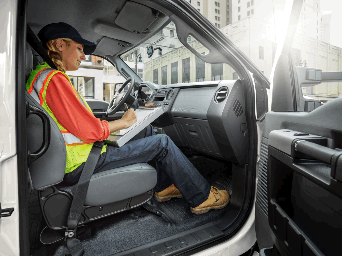 Conductrice prenant des notes dans la cabine d’un camion Ford F-650.