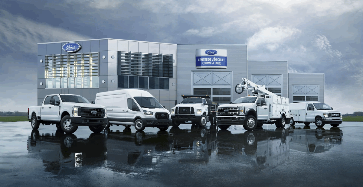 Gamme de véhicules commerciaux Ford devant un centre spécialisé au Québec.