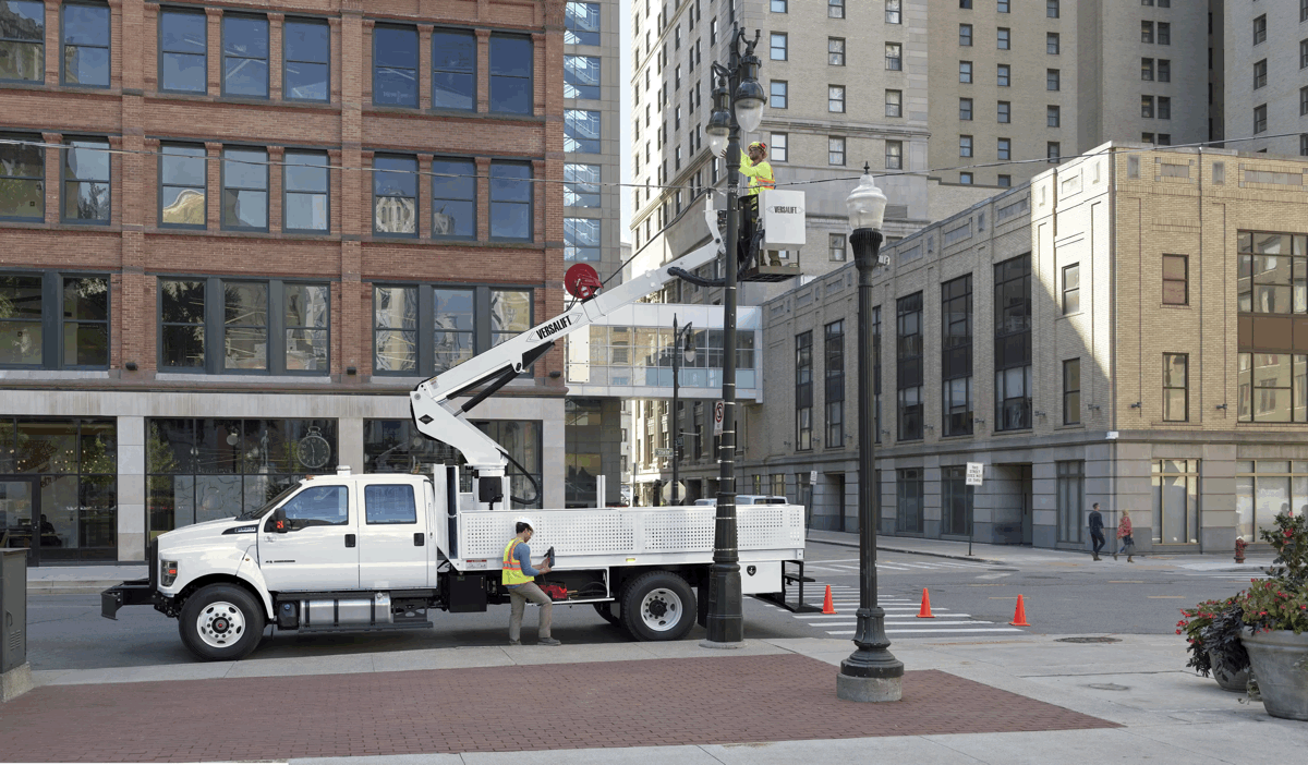 Ford F-750 blanc équipé d’une nacelle élévatrice en milieu urbain.