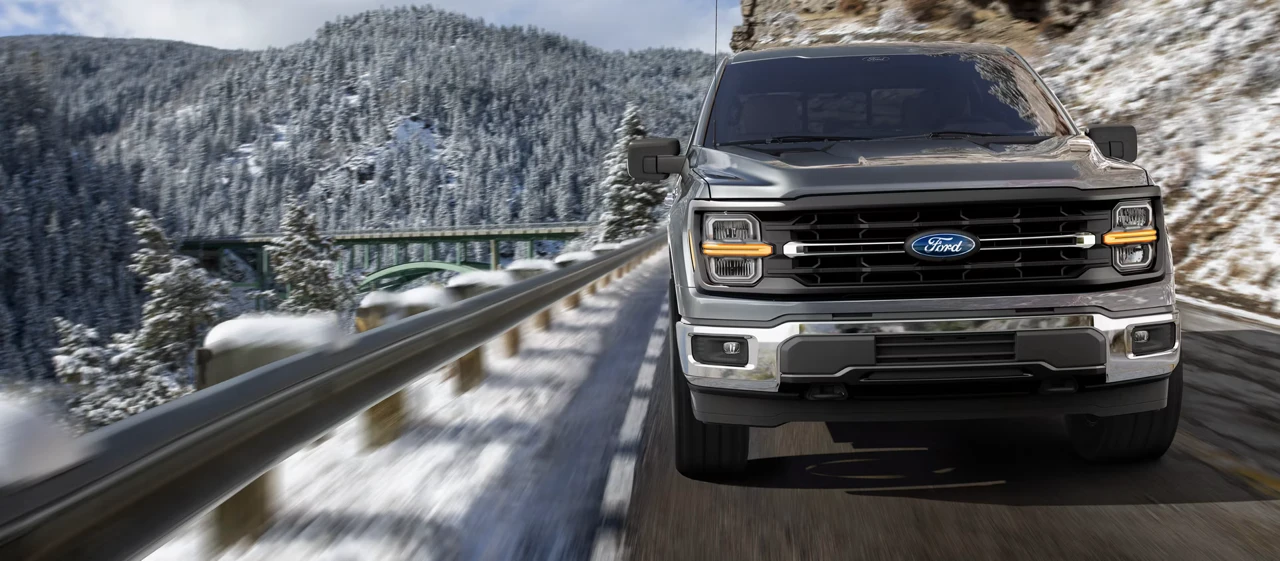 Ford F-150 2026 roulant sur une route de montagne enneigée.