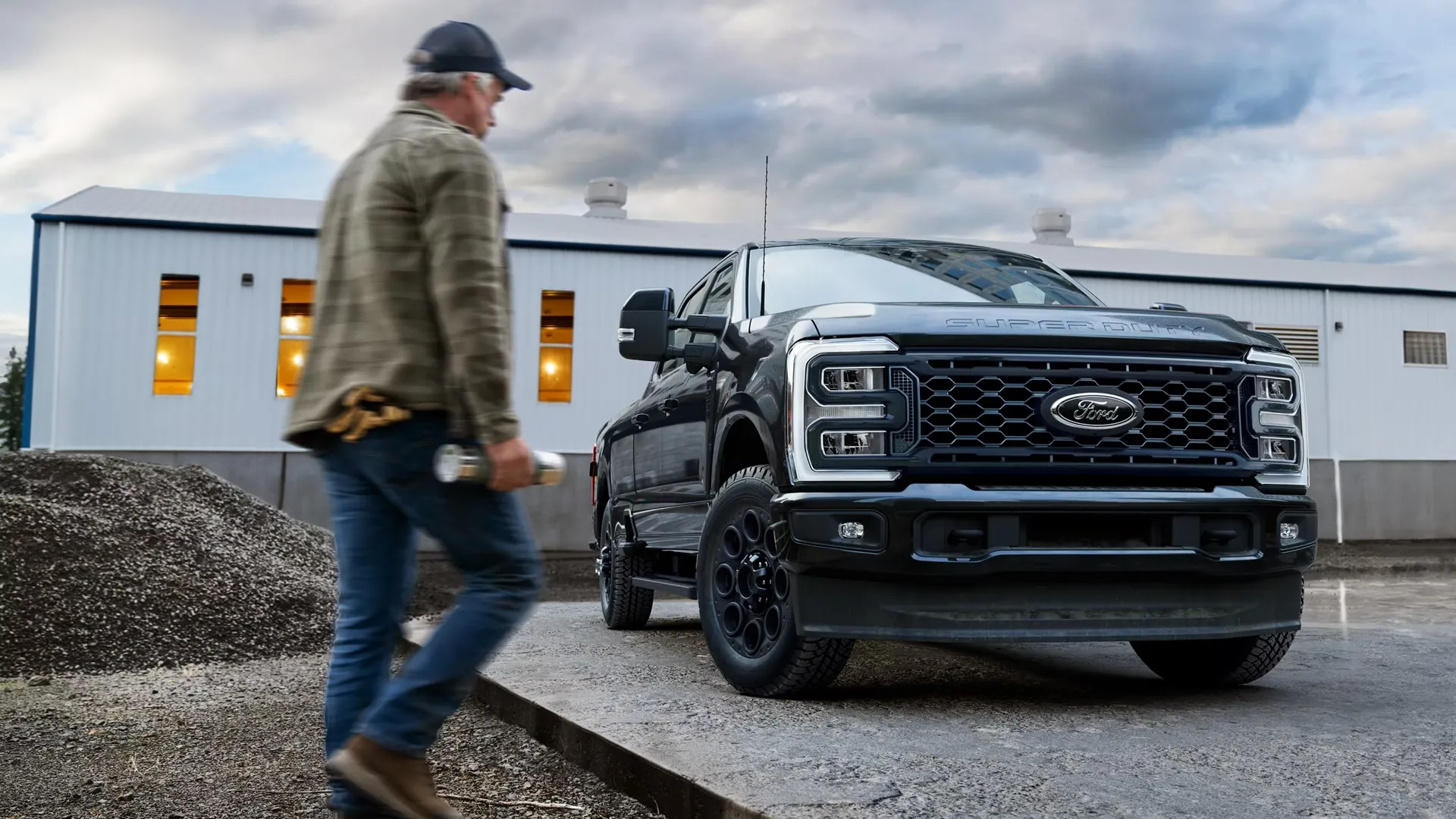 Vue avant d’un Ford Super Duty F-250 noir près d’un travailleur.