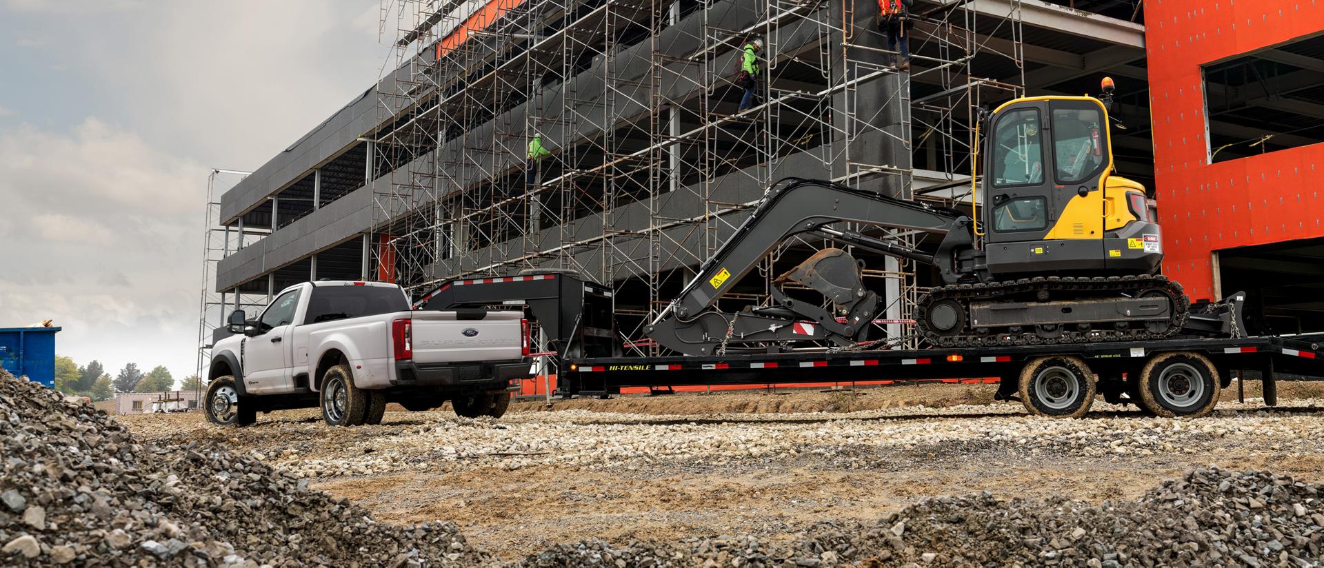 Ford Super Duty F-450 remorquant une excavatrice sur un chantier.