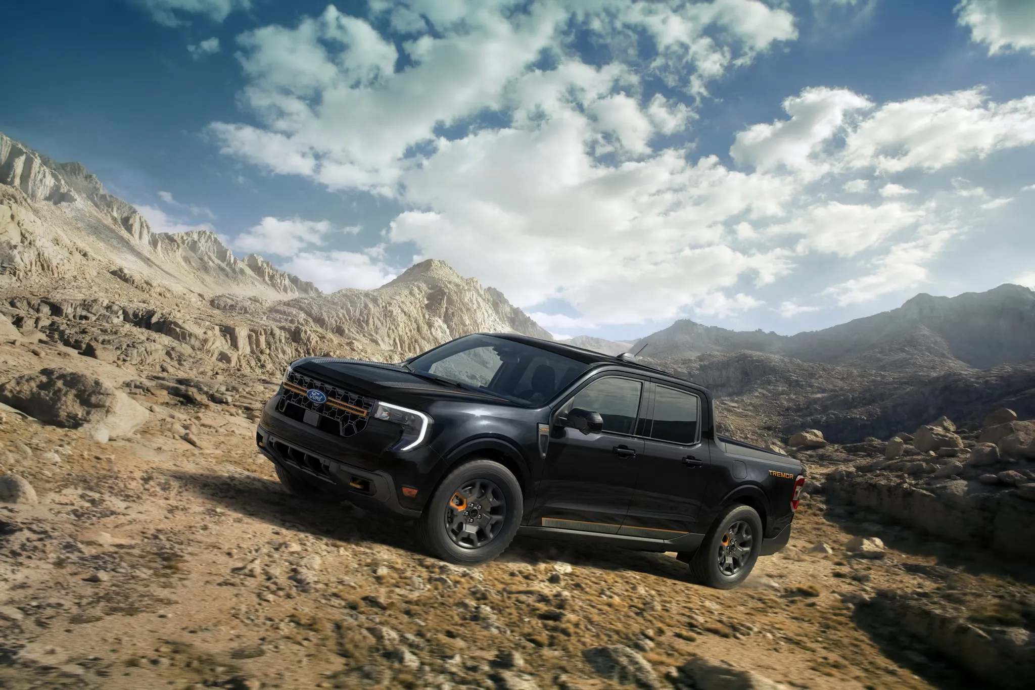 Ford Maverick 2026 noir circulant sur un sentier rocheux en montagne.