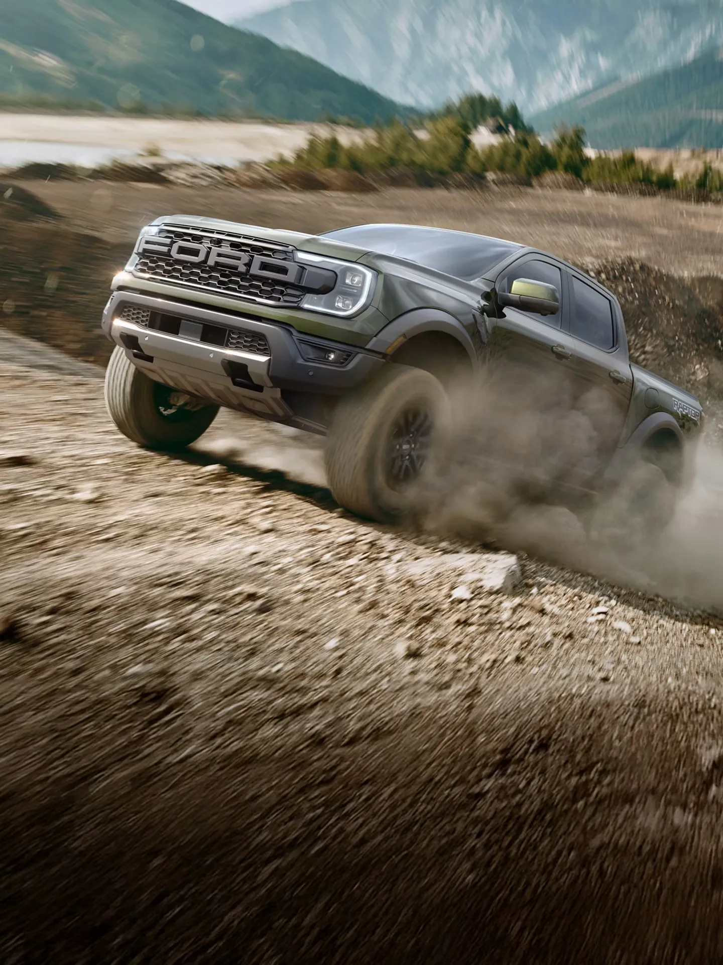 Ford Ranger 2026 gris roulant sur un terrain accidenté dans un nuage de poussière.