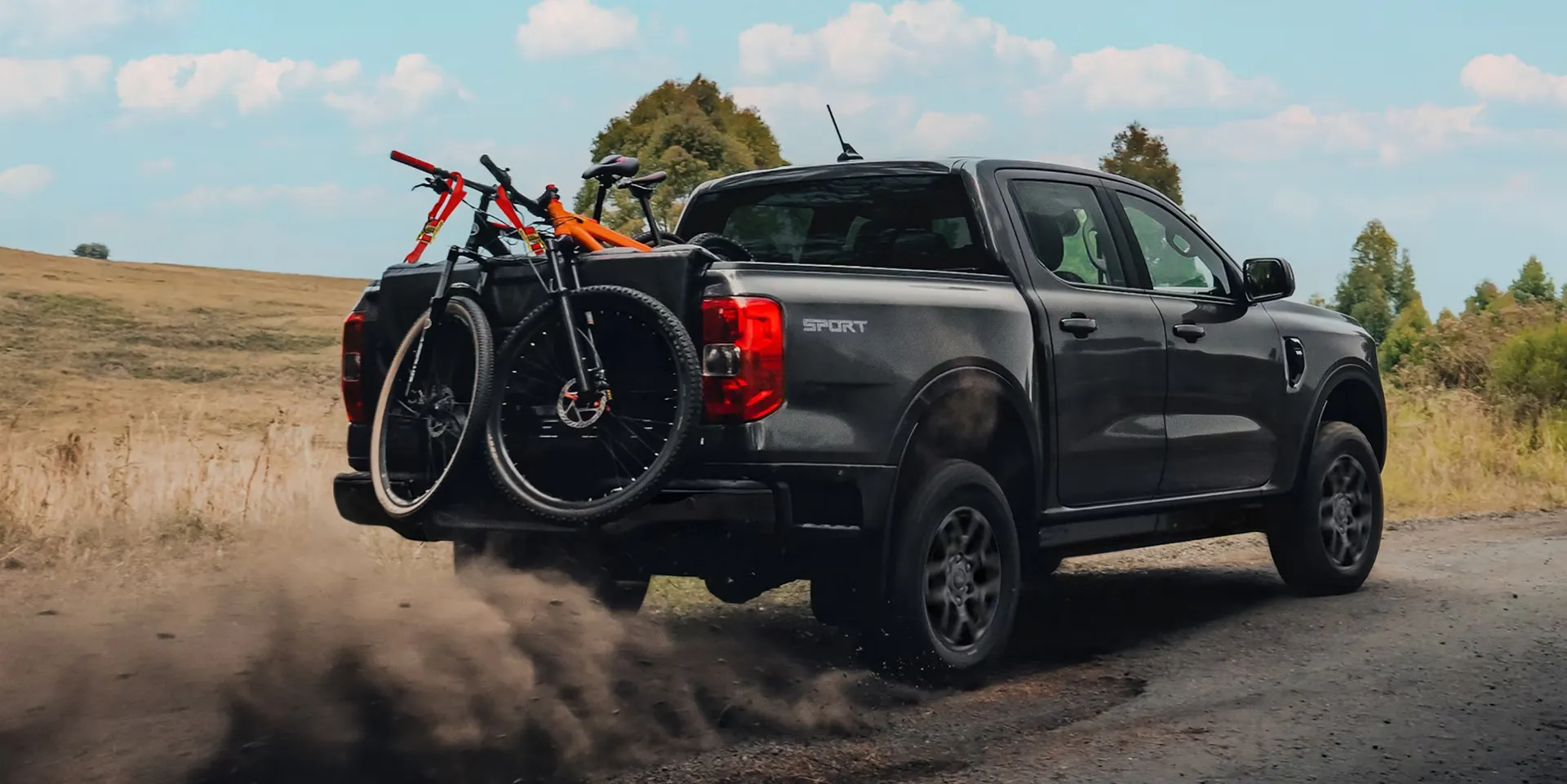 Ford Ranger gris transportant des vélos à l’arrière pour illustrer le comparatif des modèles 2025 et 2026.