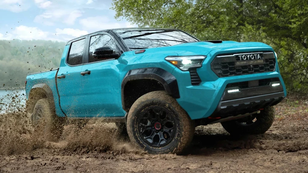 Toyota Tacoma 2026 bleu traversant un terrain boueux hors route.